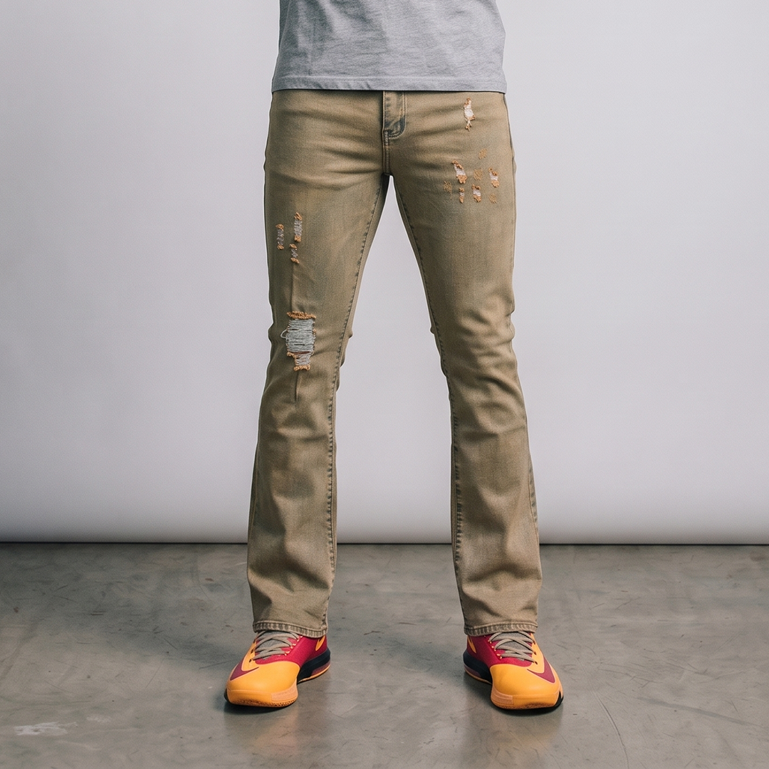 Person wearing beige distressed jeans with colorful shoes on a plain background